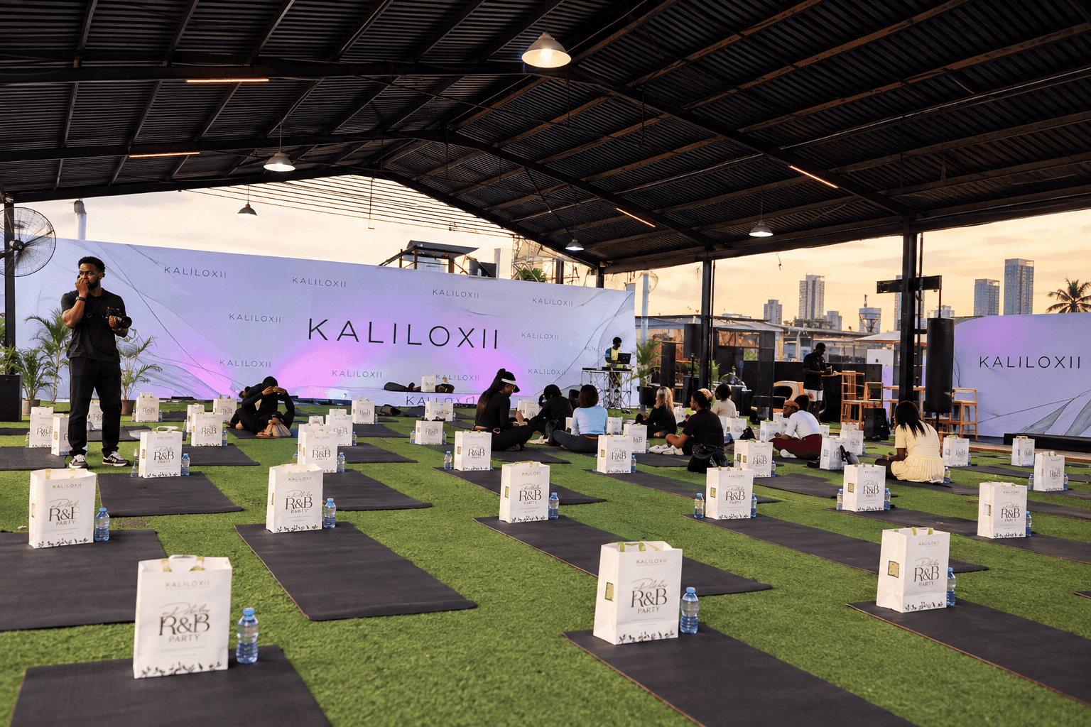 Kaliloxii wellness session — rows of mats and gift bags in front of the branded backdrop